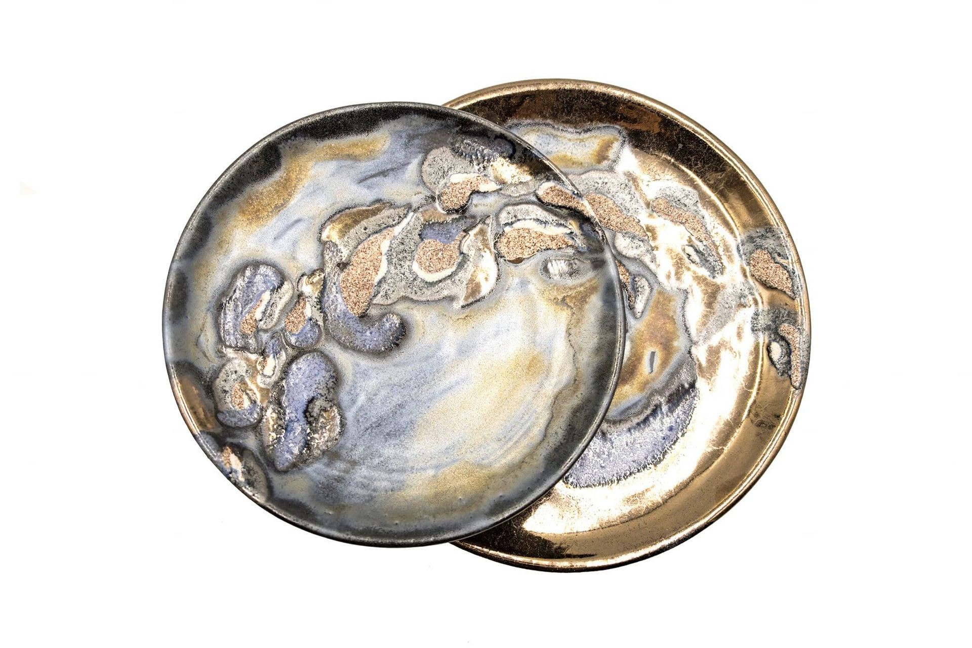 Two ceramic plates with a marbled pattern and metallic accents overlapping on a white background.